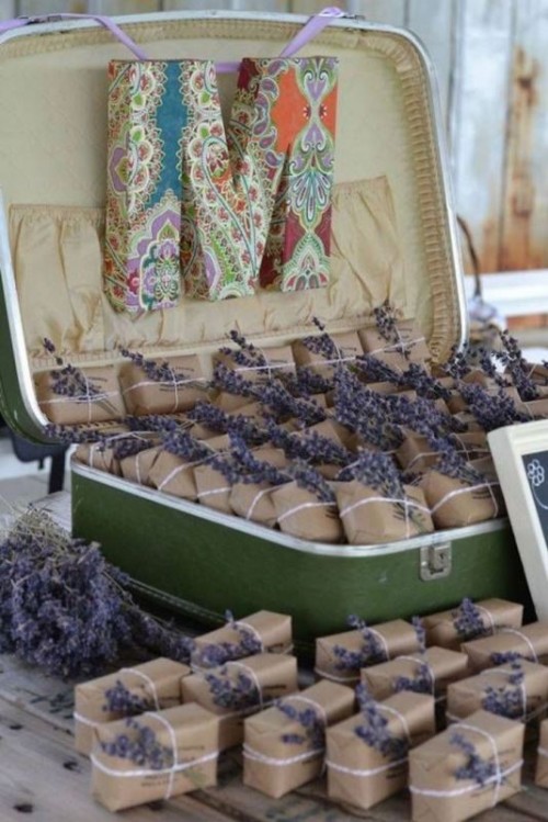 a vintage suitcase used for storing wedding favors decorated with lavender and with a large monogram is a pretty DIY you can do in a couple of minutes