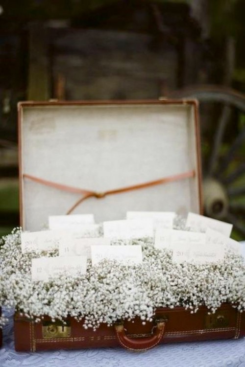 a vintage suitcase with baby's breath and escort cards is a beautiful vintage wedding decor idea to rock