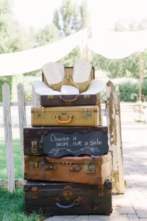 a stack of vintage suitcases, with a sign and wedding programs inside is a lovely vintage wedding decoration you can easily DIY
