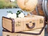 a stack of vintage suitcases with white blooms, a globe is a pretty decoration that will be perfect for a couple of travelers