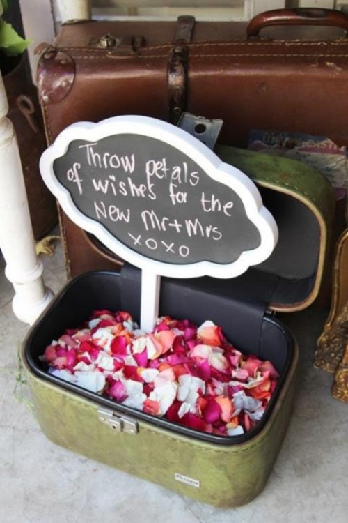 a vintage suitcase filled with petals and a chalkboard sign on top is a very cool and bold idea for any wedding, use them for your wedding exit