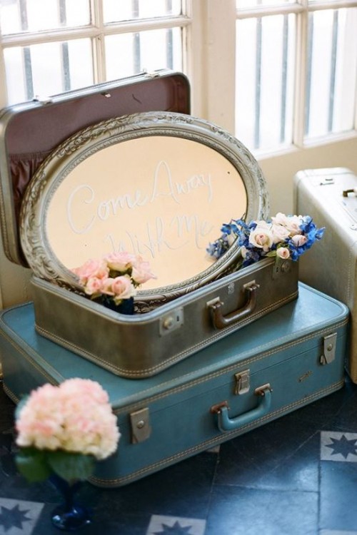 vintage suitcases stacked, an oval mirror and blue and pink blooms are amazing for wedding decor in vintage style