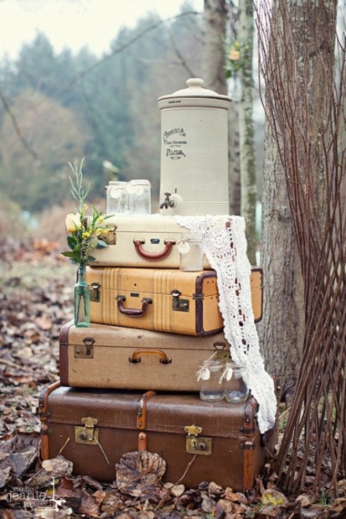 stacked vintage suitcases with lace, blooms and a tank with lemonade is an alternative to a wedding drink station, great for a small celebration