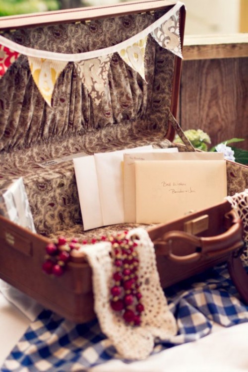 a vintage suitcase with a colorful banner, crochet lace and letters to the couple instead of cards is a cool idea for a vintage wedding