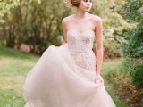 a tender blush strapless wedding dress with a layered skirt and an embellished bodice for a dreamy princess-like look