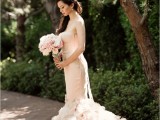 a gorgeous blush strapless mermaid wedding dress with a pretty ruffle tail and an embellished sash for a romantic bride