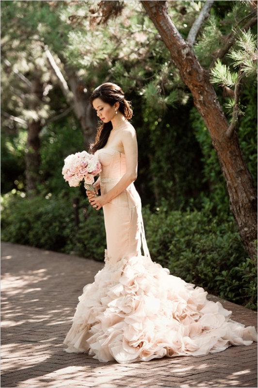 a gorgeous blush strapless mermaid wedding dress with a pretty ruffle tail and an embellished sash for a romantic bride