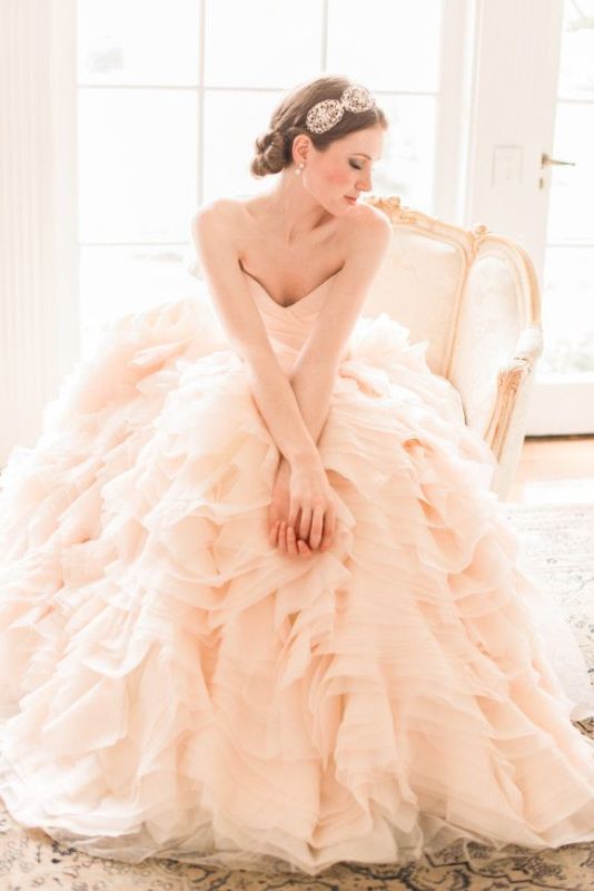a strapless blush wedding ballgown with a draped bodice, a layered ruffled skirt for a classic and chic look