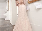 a beautiful blush lace A-line wedding dress with blush fabric blooms decorating the open back