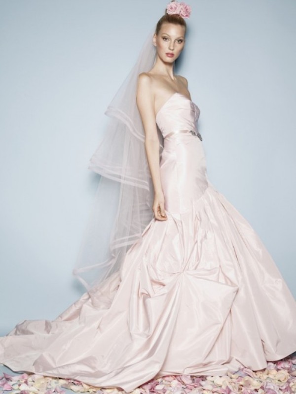 A strapless blush mermaid wedding dress with a draped bodice and skirt plus a long train