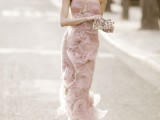 a unique very fitting blush wedding gown with sheer ruffles that form flowers looks very unusual and statement-like
