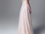 a delicate blush A-line wedding dress with an open back, illusion straps and a layered skirt for a tender outfit
