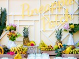 a fruit table with lots of bananas, papayas, pineapples, leaves and bright blooms is great instead of a usual dessert table