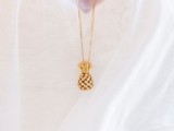 a bride wearing a tiny pineapple necklace in gold – a very creative and refined accessory