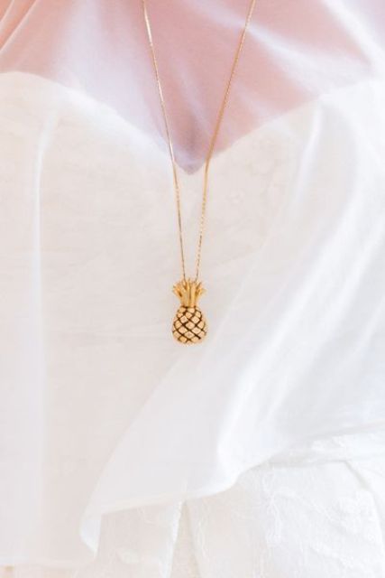 a bride wearing a tiny pineapple necklace in gold - a very creative and refined accessory