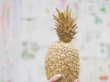 a gilded pineapple as a wedding decoration is a very cool and cute idea, you can eat it later