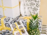 wedding favors wrapped into paper with pineapple prints is a very cool idea for a tropical wedding