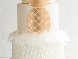 a white and copper wedding cake with a pineapple texture, white petals and a chic copper pineapple for a modern tropical wedding