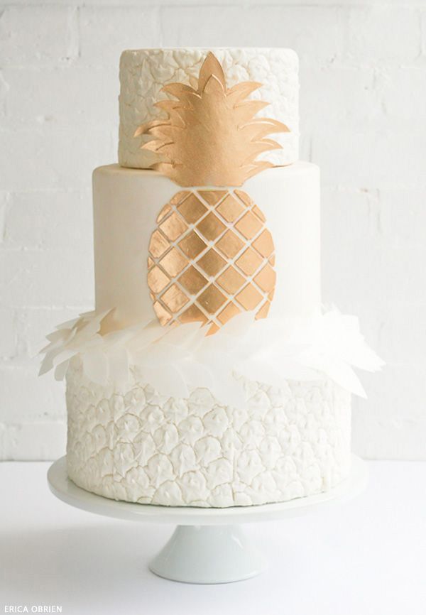 A white and copper wedding cake with a pineapple texture, white petals and a chic copper pineapple for a modern tropical wedding