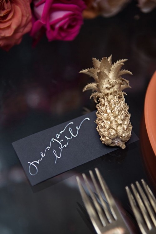 a glam and chic place setting with a gold pineapple and a black card is a very chic and refined idea