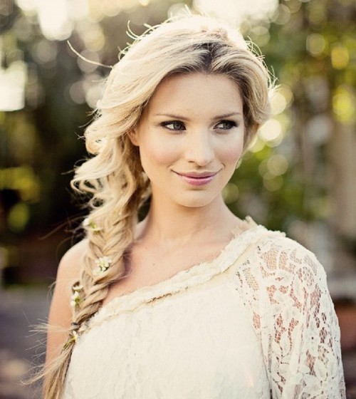 a lovely side fishtail braid with a volume on top and some fresh blooms is a cool idea for a boho bride