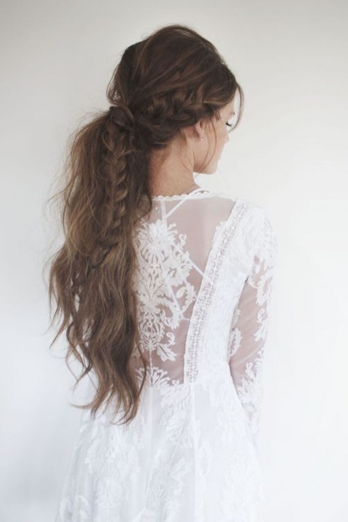 a boho chic low ponytail with several braids, textural waves down and a volume on top looks super boho and wild