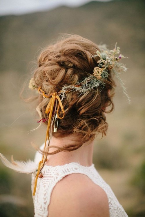 a messy and twisted updo with a volume on top and some locks down and a dried flower crown is a great solution for a fall boho bride