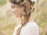 a messy boho chic side braid with a volume on top and a bright floral crown is a great idea for a spring or summer boho bride