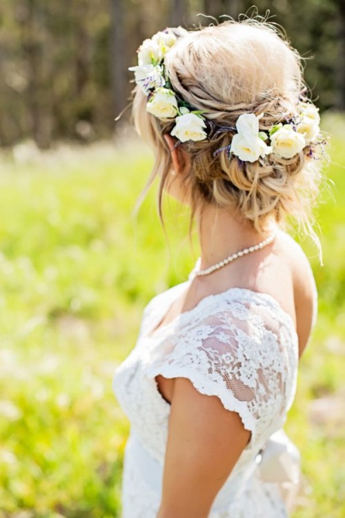 a messy and twisted updo with a bit of locks and some fresh neutral blooms is a lovely idea for a boho bride