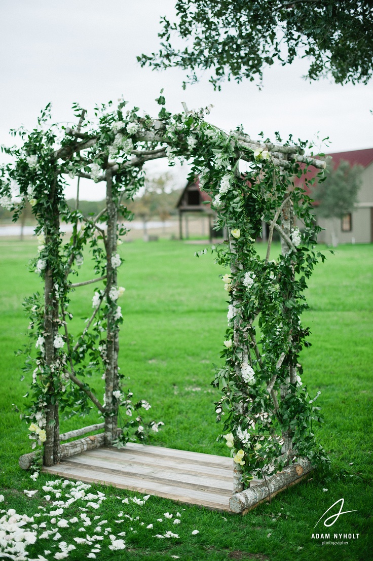 a very fresh spring wedding arch done only with greenery and white blooms is very inspiring