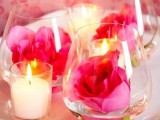 glasses with pink roses and candles around for a bright and lovely wedding centerpiece at Valentine’s Day