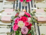 a bold and chic Valentine’s Day wedding centerpiece with hot pink, lavender, white blooms and greenery sets the tone at the table