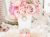 a white embellished bucket with pink and blush roses is a pretty glam and bright Valentine’s Day wedding centerpiece