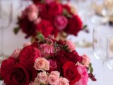 a bold and refined centerpiece of red, fuchsia, light pink blooms and some greenery is a beautiful idea