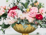 a beautiful Valentine’s Day wedding centerpiece of a gold bowl with pink, red and blush blooms and greenery is pure elegance and chic
