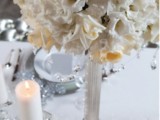 an elegant and formal white bloom centerpiece with pillar candles is a stylish idea to try