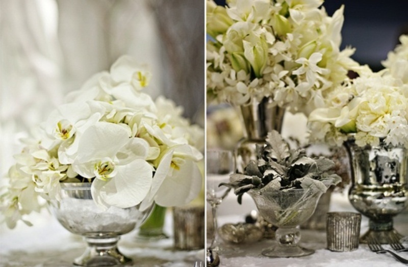 An elegant winter wedding centerpiece of silver bowls and vases with white blooms looks chic and refined