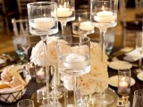 an elegant formal wedding centerpiece with white blooms and floating candles on a mirror