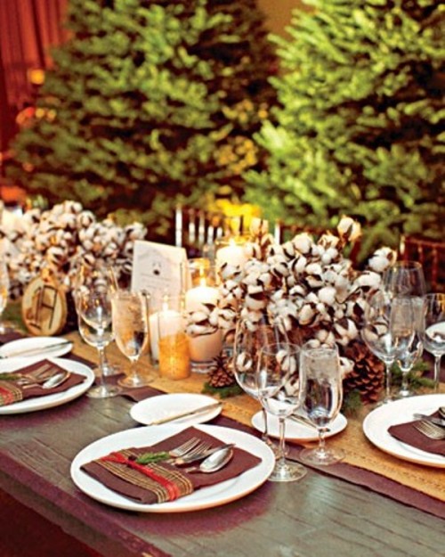cozy winter wedding centerpiece of cotton arrangements and pillar candles plus wood slices feel cozy and rustic