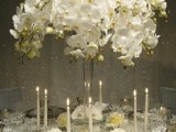 a white orchid wedding centerpiece in a tall vase is a stylish and refined idea for a wedding