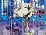 a winter wedding centerpiece of white blooms, with branches with crystals hanging down
