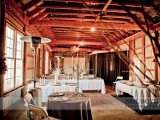 a rustic barn reception space with branches, trees, lights, lights and lamps is welcoming