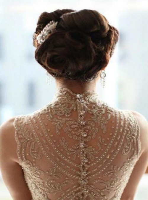 a jaw-dropping wedding dress illusion back done with gold lace, rhinestones and a row of rhinestone buttons is pure glam and sophistication