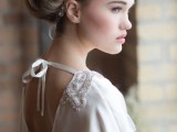 a beautiful modern wedding dress of sheer and plain fabric with a cutout back on ties and embellished shoulders is beautiful