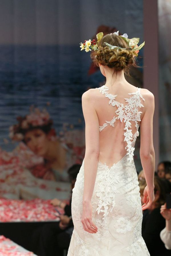 A charming floral mermaid wedding dress with an open back accented with lace flower garlands is a dreamy idea for a fairy tale bride