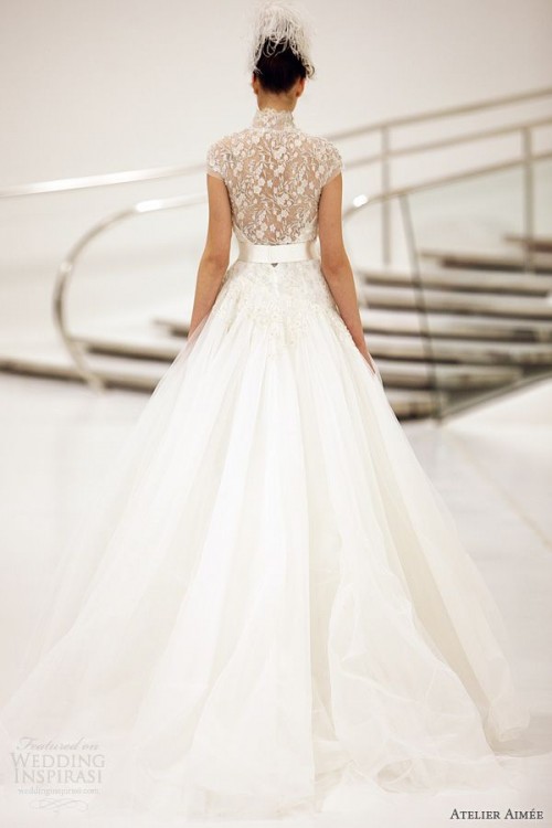 a sophisticated A-line wedding dress with a lace applique illusion back, a high neckline and cap sleeves and a plain full skirt with a train is beautiful