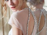 a beautiful modern fitting wedding dress with a statement back – a sheer and cutout one with oversized rhinestones that line up the cutouts is amazing