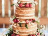 a naked wedding cake topped with fresh strawberries and white blooms and greenery is a cool rustic summer wedding piece