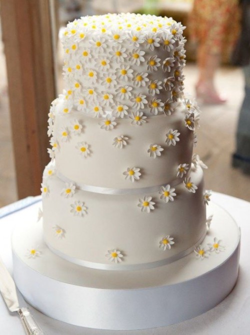 a white buttercream wedding cake decorated with white sugar blooms looks veyr informal, rustic and relaxed