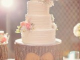 a white textural buttercream wedding cake decorated with white and pink blooms and greenery is a stylish rustic idea